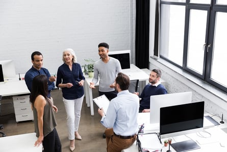 a group of people standing around a desk