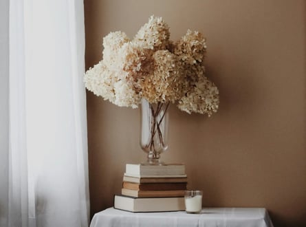 Flores secas sobre livros representando um espaço calmo e consciente de inspiração e regeneração