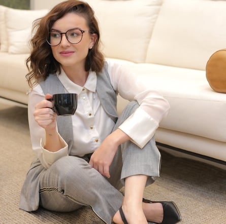 Purpose mentor sitting on the floor in gray and white, holding a cup of coffee