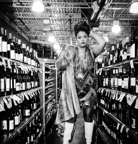 Keri Elle -woman in a dress and gogo boots is standing in a store- fur coat, captured by Taye Rose