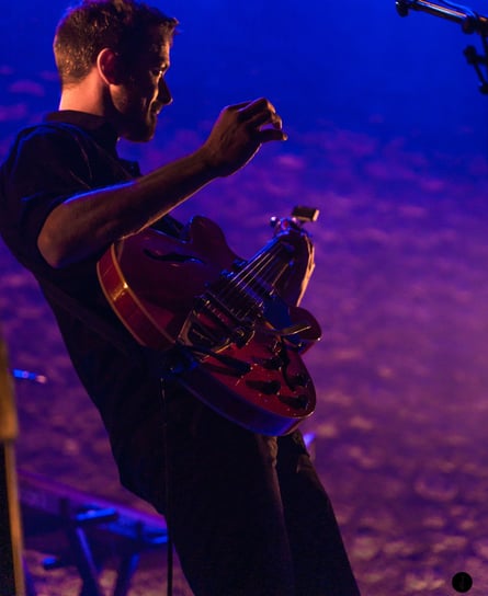 a man playing a guitar on stage