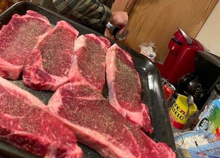 Raw new york strip steaks salt and peppered ready for the grill