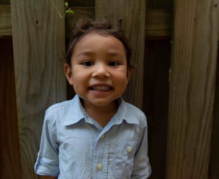 A young boy smiling at the camera.