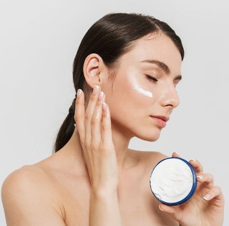 woman mosturizing her face