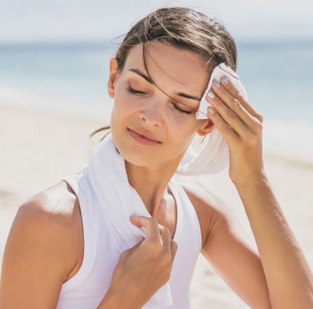 woman wiping sweat off of her face
