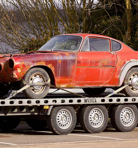 a car is being towed down a flatbed trailer