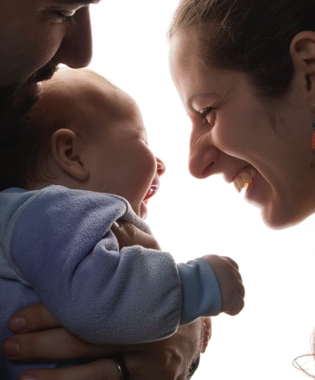 a man and woman holding a baby in a photo