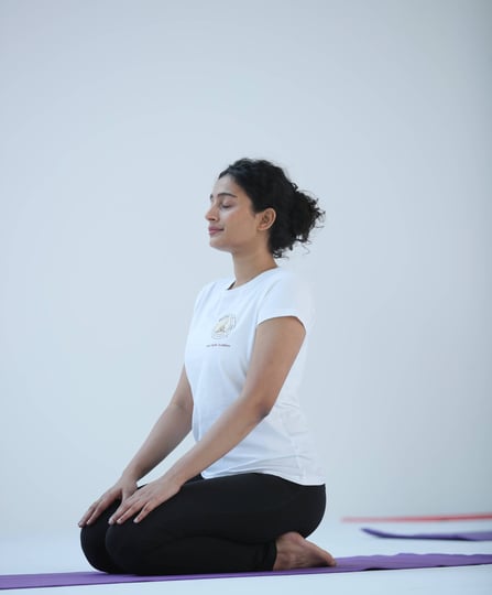 an image of a girl doing yoga with white tshirt and black pant of hathavidya 