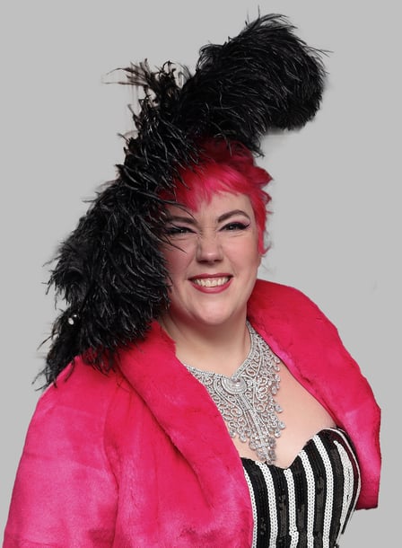 a woman with a pink jacket and a black ostrich feather hat