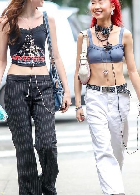 Modelo feminino com camiseta listrada, calça de moletom, jaqueta de couro e botas.