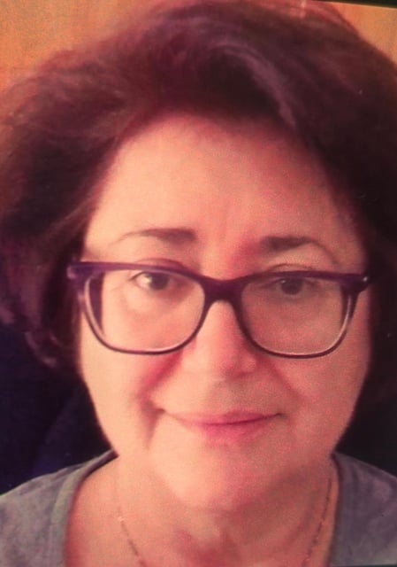 a woman with glasses and a necklace on her neck