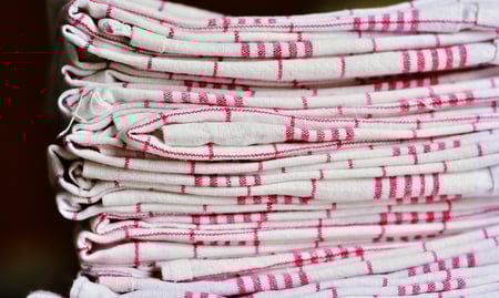 Stack of folded cloth napkins in checkered patterns, eco-friendly alternatives to paper napkins