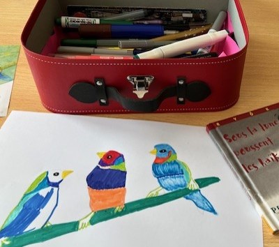 Photo de Magali STrassel, art-thérapeute, montrant un dessin d'oiseaux colorés