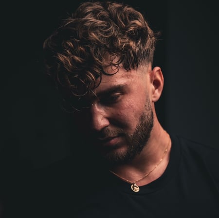 Portret artistic al antrenorului, cu privirea în jos, reflectând intensitatea și dedicarea