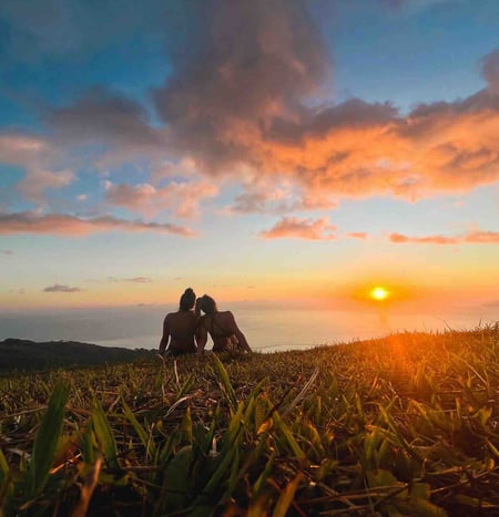 Eva and Manon watching the sunset in Tahiti, with the ocean in the background.