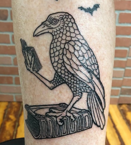 Reading raven standing on book tatttoo