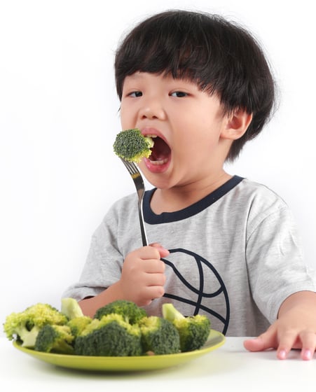 Copertina eBook Guida Sana all’Alimentazione per Genitori: bambino che sorride con broccoli.