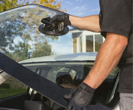 a man in a black shirt is holding a WINDSHIELD