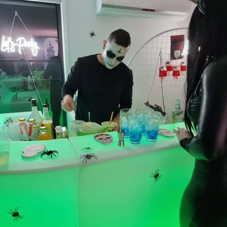 Bartender preparing drinks at the glow bar decorated for halloween event in Brisbane.
