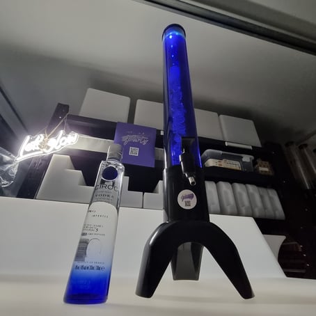 Blue glowing drink tower with ice cube tube, on a glow bar with lets glow neon behind in Redlands.