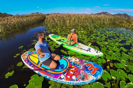 two people are sitting on paddle boards in the water