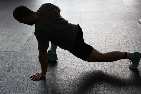 un homme fait du gainage et de l'activité physique au poids du corps