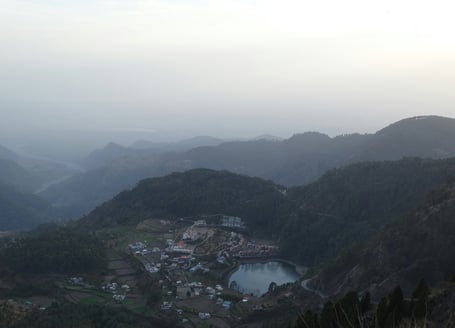 a view of a mountain range with a lake and a small town