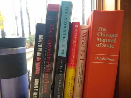 A windowsill holding several books and a coffee cup