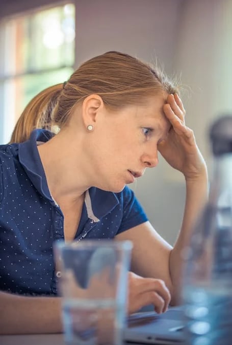 a woman sitting at a table with a laptop computer