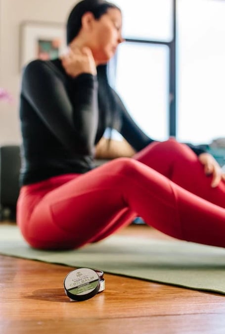 a woman sitting on a yoga mat with a cell phone