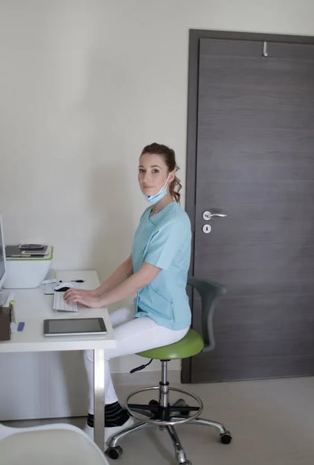 a woman sitting at a desk with a laptop computer