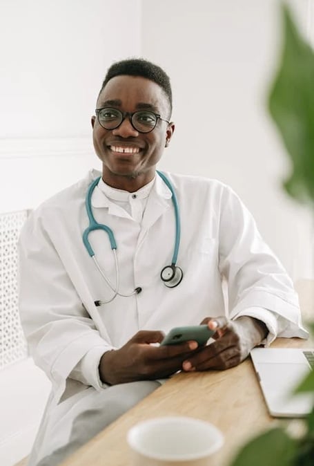 a smiling doctor in a white coat and glasses