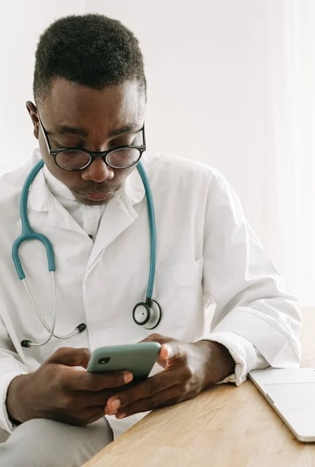 a male doctor in a white coat and a laptop