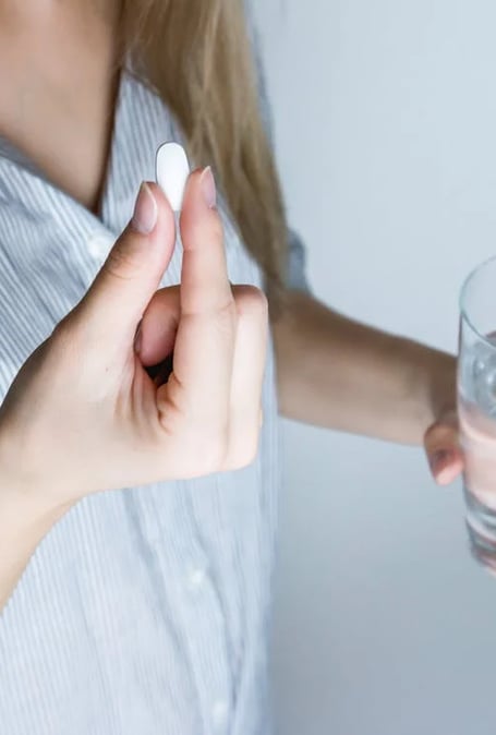 a woman holding a pill pill in her hand