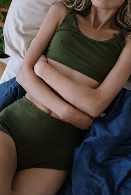 a woman in a green top and a white bottom