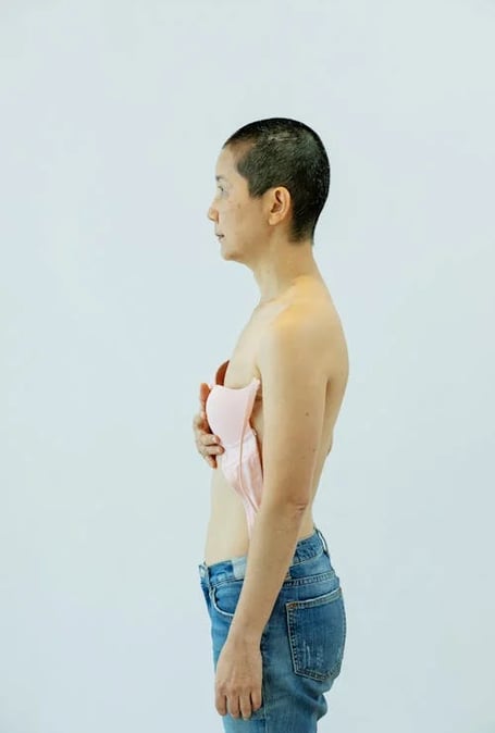 a woman in jeans and a pink bra