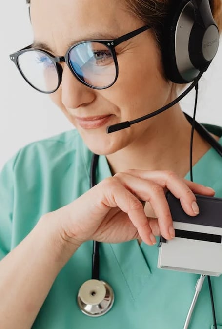 a nurse in a green scrub suit and headphones