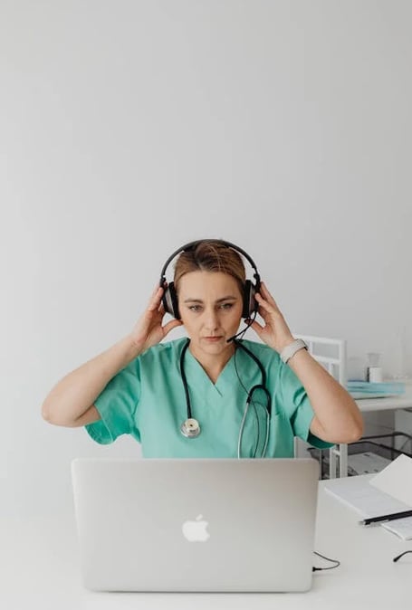 a woman in a green scrub suit and a stethoscope on her head