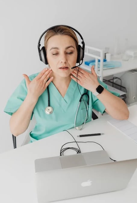 a woman in a green scrub suit and headphones