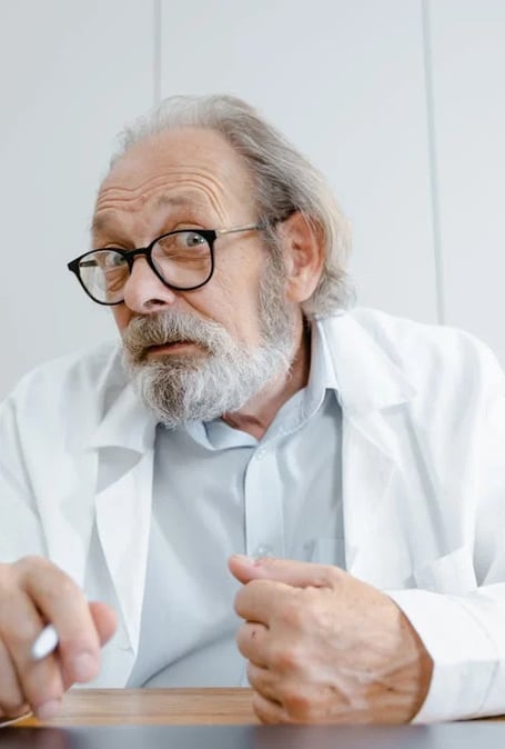 a man in a lab coat sitting at a desk