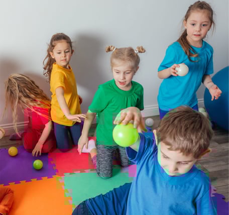 vaikai darzelyje su spalvotais marskineliais