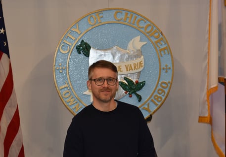 a portrait of the candidate in front of the Chicopee seal