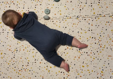 a baby is laying on a floor with a teddy bear