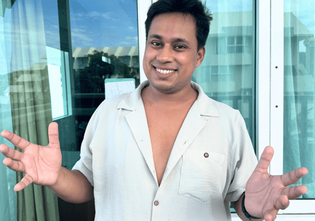 Nikhil, a boy Standing and smiling with open arms 