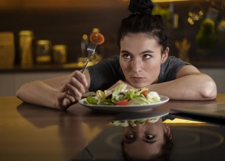 femme essayant de manger sainement mais triste