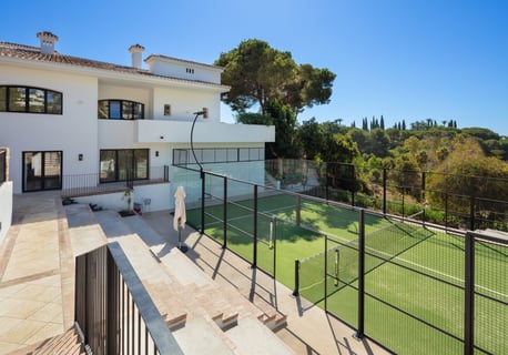 Private paddle tennis court at Villa La Gratitud, surrounded by lush greenery.