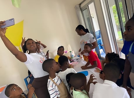 La directrice nelly prend une photo avec les enfants des l'ateliers créatifs à l'institut des frères