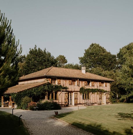 a house with a large wooden house domain de Petiosse