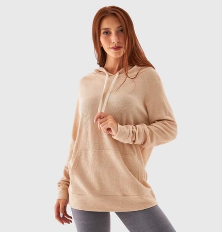 a woman in a beige hoodie and leggings