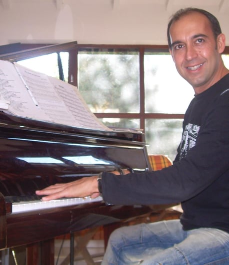 a man sitting at a piano playing a piano